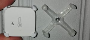 Hållare till Xiaomi Aqara temperatursensor i transparent till höger och vit till vänster.